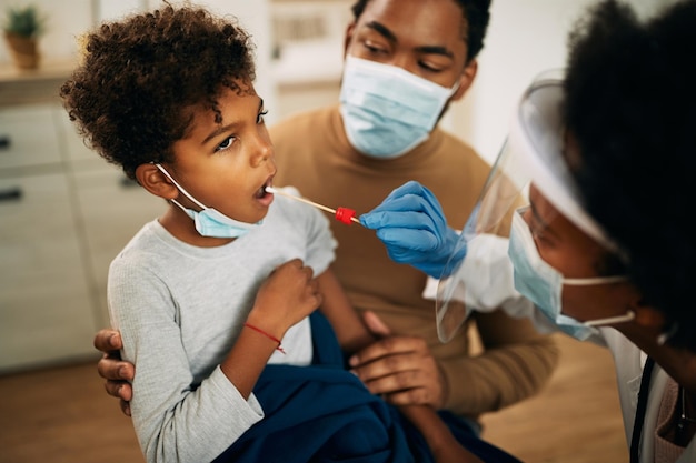 Photo gratuite petit garçon noir ayant un test pcr à la maison pendant la pandémie de coronavirus