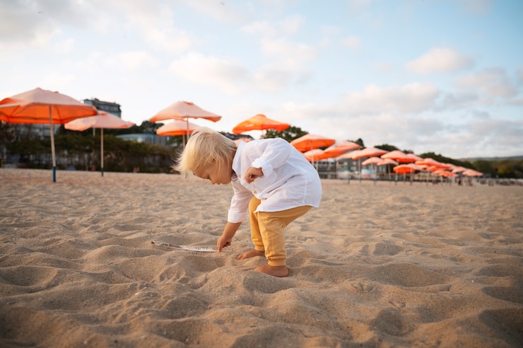 Photo gratuit un petit garçon sur la plage au coucher du soleil