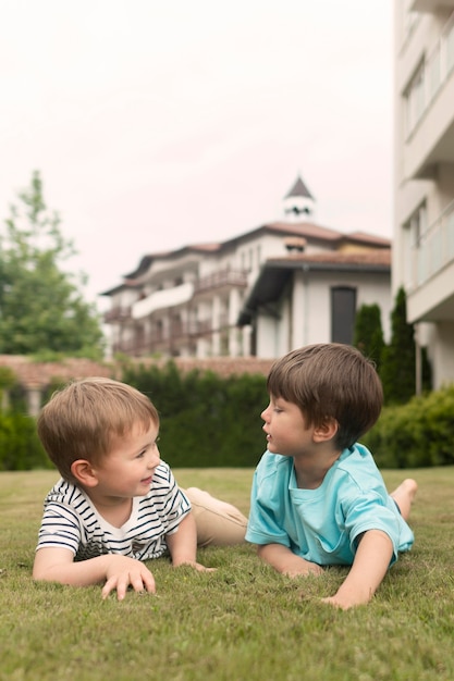 Photo gratuite petit garçon posé sur l'herbe