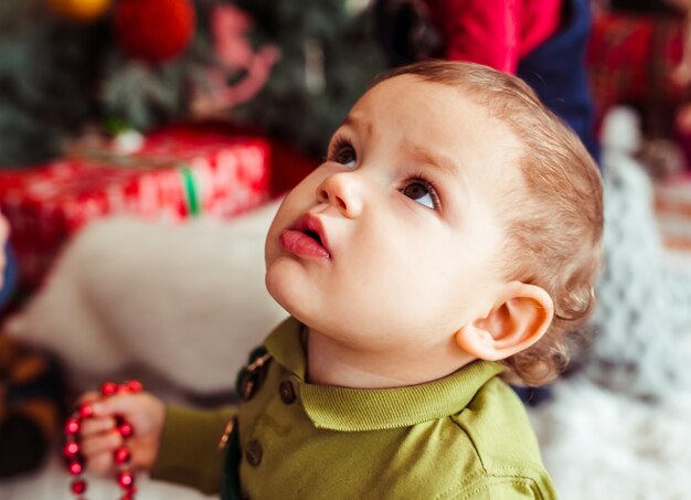 Le petit garçon en regardant l&#39;arbre de Noël