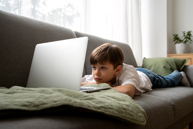 Petit garçon regardant des films sur l'ordinateur portable