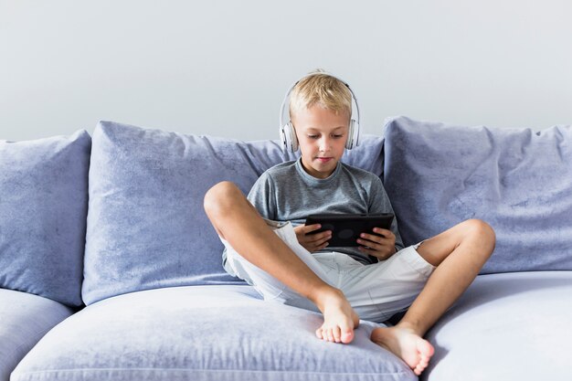 Petit garçon s'amusant avec tablette et écouteurs