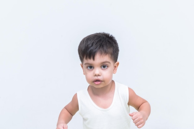 Petit garçon en t-shirt blanc sur fond blanc