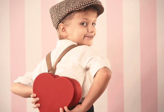 Petit garçon tenant un petit cadeau de la Saint-Valentin