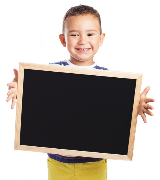 Petit garçon tenant un tableau noir