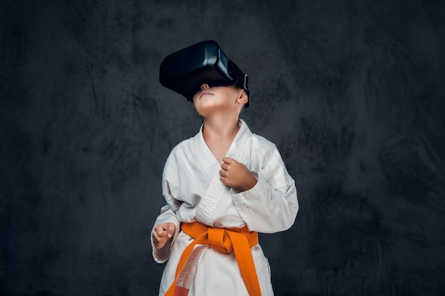 Petit garçon vêtu d'un kimono blanc avec des lunettes VR sur la tête.