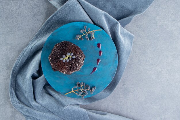 Un petit gâteau au chocolat sucré sur une plaque bleue