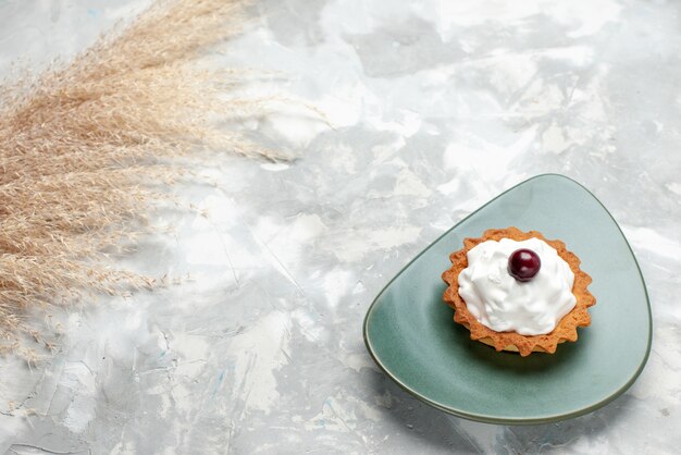 petit gâteau crémeux à l'intérieur de la plaque sur le bureau léger, gâteau crème aux fruits biscuit sucré