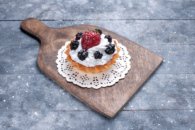 Petit gâteau délicieux avec de la crème et des baies sur un sol léger gâteau biscuit sucre sucré photo cuire berry