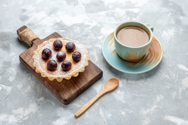 Petit gâteau délicieux avec du sucre de fruits en poudre avec du café au lait sur la lumière, gâteau biscuit gâteau sucré