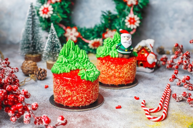 Petit gâteau de Noël décoré de douces figures d'arbre de Noël, de père Noël et de bougies.