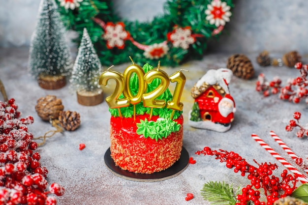 Petit gâteau de Noël décoré de douces figures d'arbre de Noël, de père Noël et de bougies.