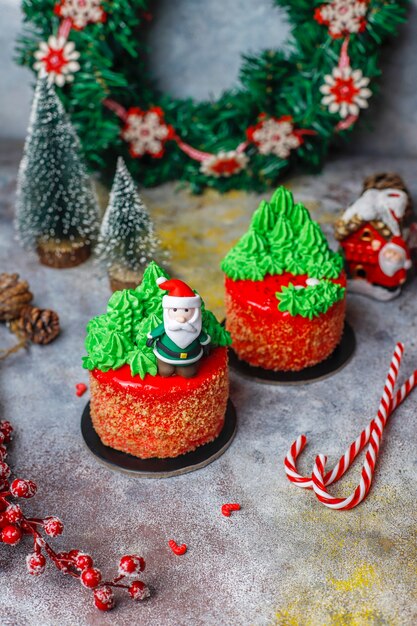 Petit gâteau de Noël décoré de douces figures d'arbre de Noël, de père noël et de bougies.