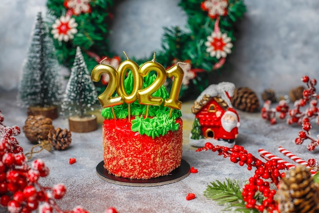 Petit gâteau de Noël décoré de douces figures d'arbre de Noël, de père noël et de bougies.