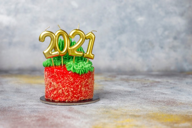 Petit gâteau de Noël décoré de douces figures d'arbre de Noël, de père noël et de bougies.