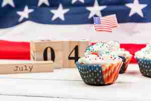 Photo gratuite petit gâteau sucré à la crème fouettée avec des drapeaux américains et des cubes en bois