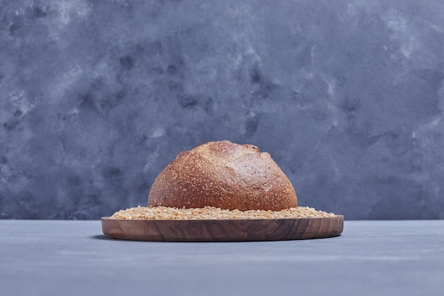 Petit pain rond fait à la main sur le plateau de blé.