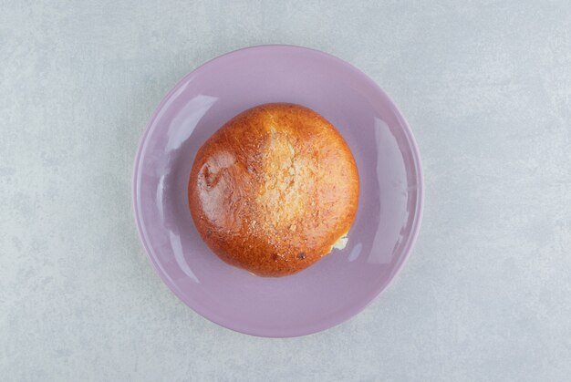 Petit pain simple sucré sur plaque violette.