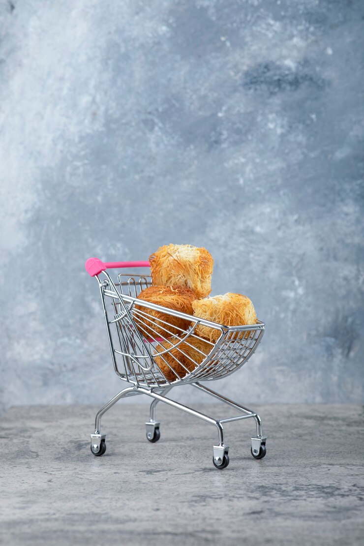 Photo gratuit un petit panier rose de délicieux biscuits placés sur une table en marbre.