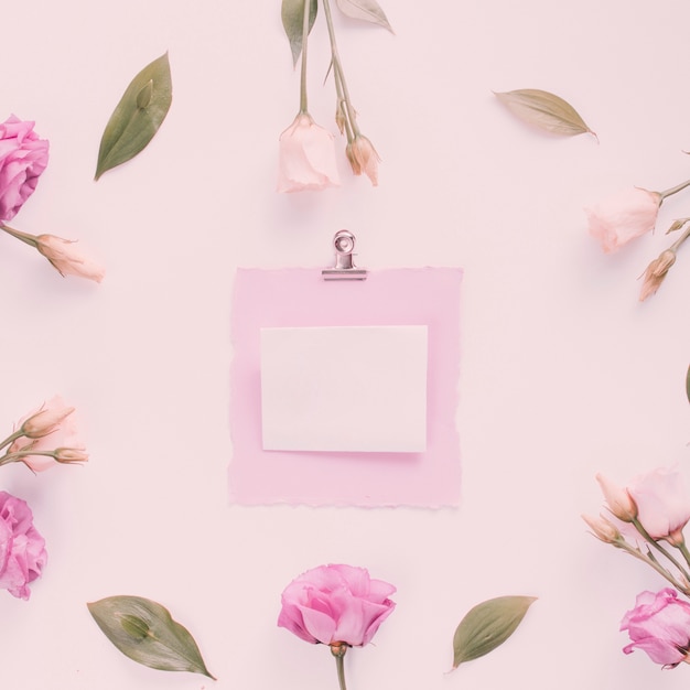 Photo gratuite petit papier avec des fleurs roses sur la table