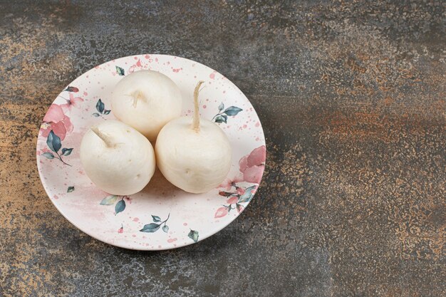 Petit radis de jardin sur l'assiette, sur la surface en marbre