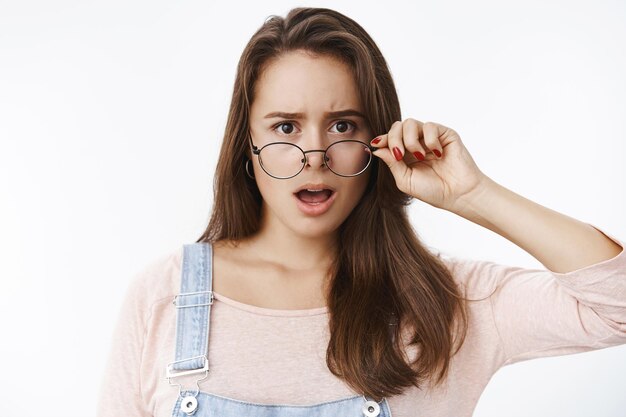 Petite amie choquée déçue réagissant secouée et impressionnée par un comportement horrible laissant tomber la mâchoire haletant mécontent et fronçant les sourcils, enlevant les lunettes d'insatisfait réagissant à une terrible nouvelle