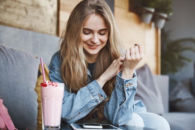 Petite amie européenne élégante avec des cheveux blonds en veste en jean sitt