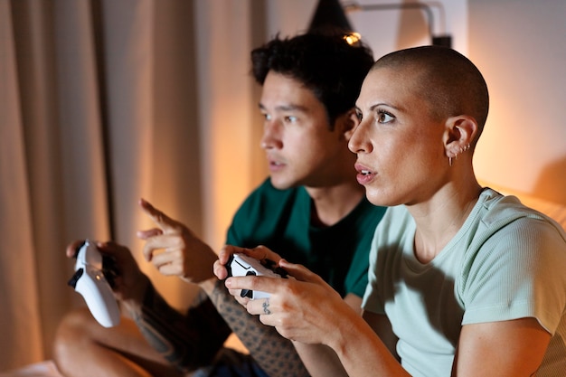Petite amie et petit ami jouant à des jeux vidéo ensemble à la maison