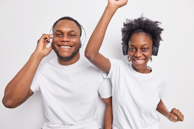 petite amie et petit ami se détendre ensemble écouter la musique préférée de la liste de lecture bouger au rythme de la musique porter des t-shirts blancs décontractés poser à l'intérieur