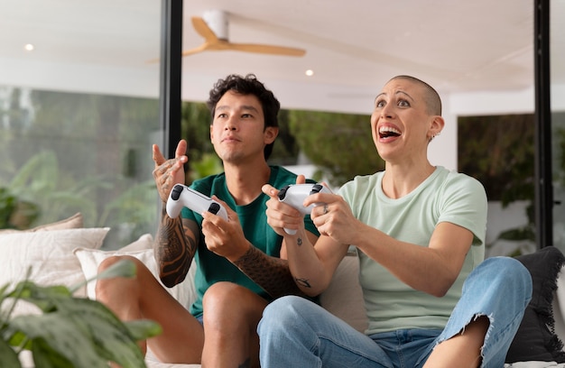 Une petite amie et son petit ami jouent ensemble à des jeux vidéo à la maison.