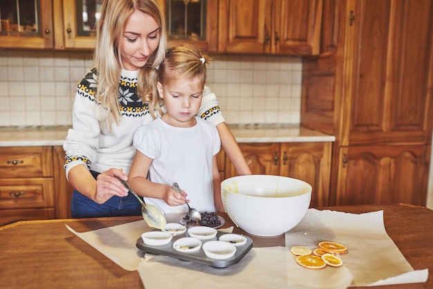 Photo gratuite une petite belle fille prépare des cupcakes