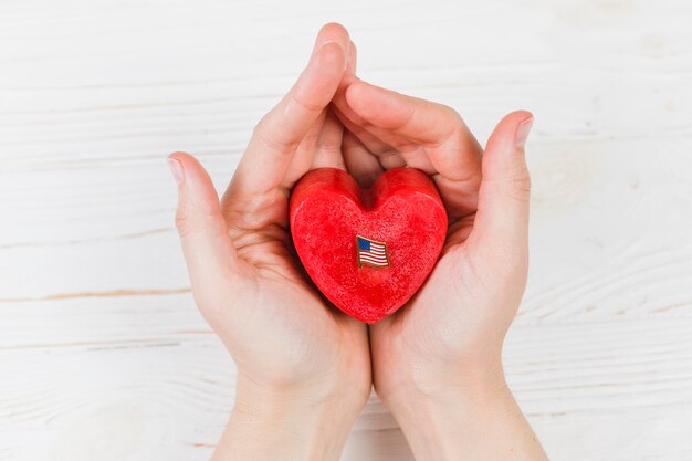 Petite boîte cadeau en forme de coeur dans les mains