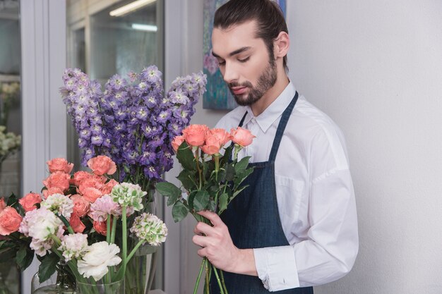 Petite entreprise. Fleuriste mâle en magasin de fleurs. faire des décorations et des arrangements