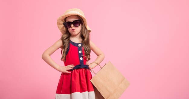 petite fashionista sur fond coloré dans les chaussures de maman