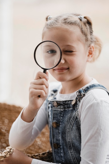 Photo gratuite petite fille à l'aide d'une loupe