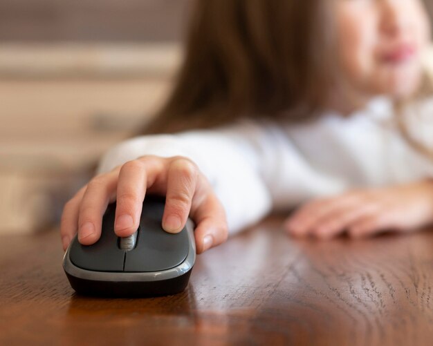 Petite fille à l'aide d'une souris d'ordinateur