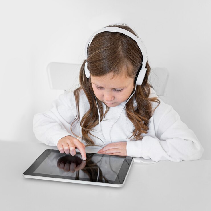 Photo gratuit petite fille à l'aide de tablette avec un casque