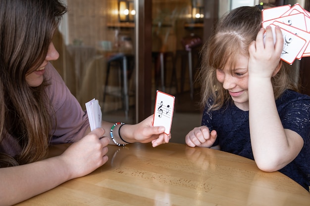 Une petite fille apprend les notes de manière ludique, à l'aide de cartes musicales spéciales