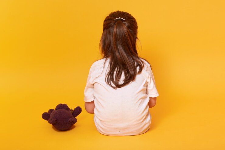 Photo gratuit petite fille assise en arrière avec ours en peluche brun