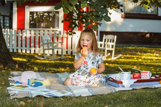 La petite fille assise sur l'herbe verte