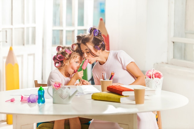 Petite fille assise avec sa mère et manger de la glace