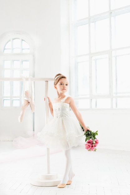 Petite fille ballerine dans un tutu. Adorable enfant dansant le ballet classique dans un studio blanc.
