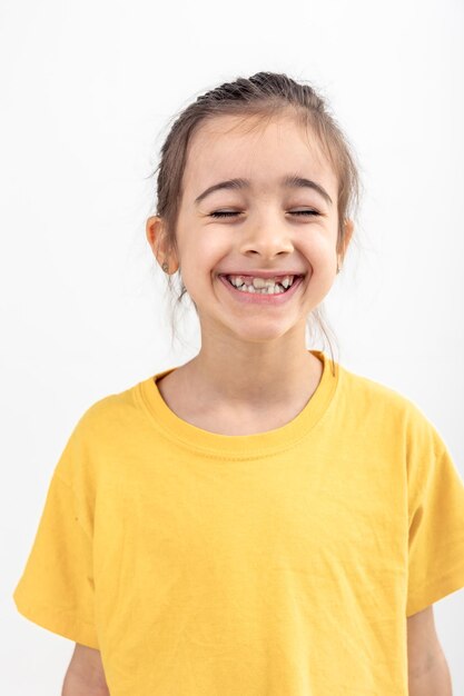 Une petite fille blanche heureuse souriante sur un fond blanc isolée de près