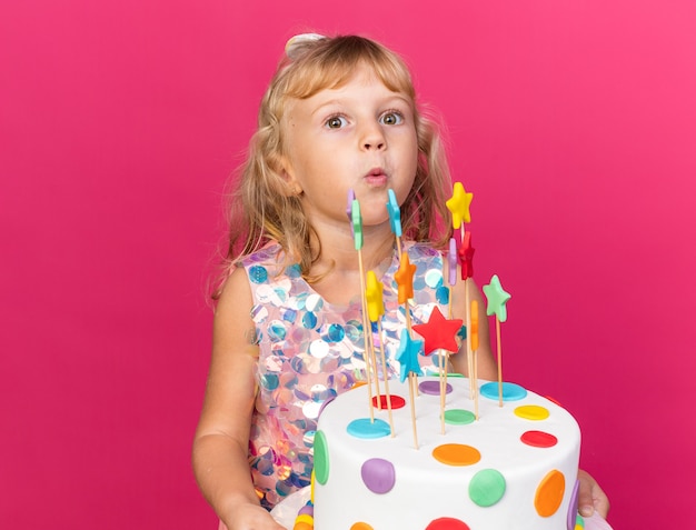 Petite Fille Blonde Excitée Tenant Un Gâteau D'anniversaire Isolé Sur Un Mur Rose Avec Espace Pour Copie