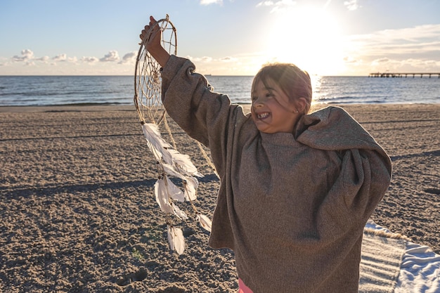 Petite Fille Avec Un Capteur De Rêves Au Bord De La Mer Au Coucher Du Soleil