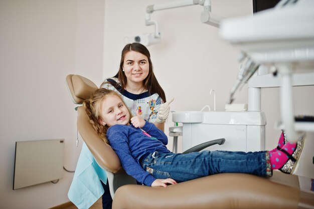 Petite fille à la chaise de dentiste Soins dentaires pour enfants