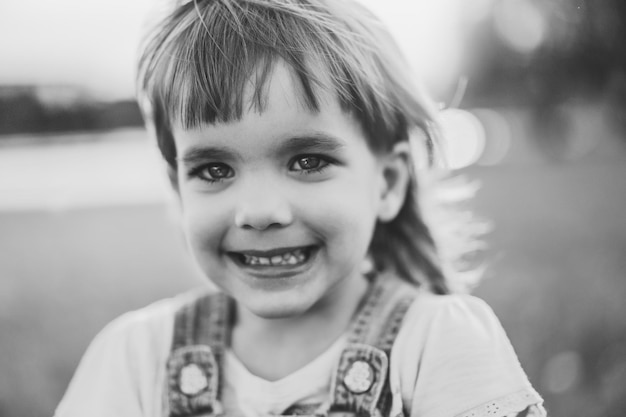 Petite fille sur un champ de pissenlit, au coucher du soleil, enfant heureux émotionnel.