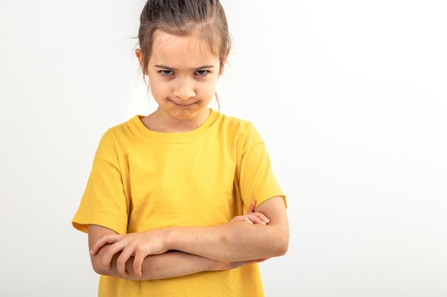 Photo gratuite une petite fille en colère avec les mains croisées sur un fond blanc isolé