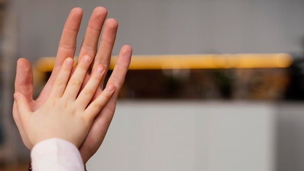 Petite fille comparant la main avec celle de son père