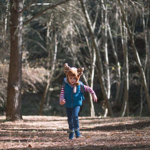 Petite fille en cours d&#39;exécution et de randonnée dans les bois